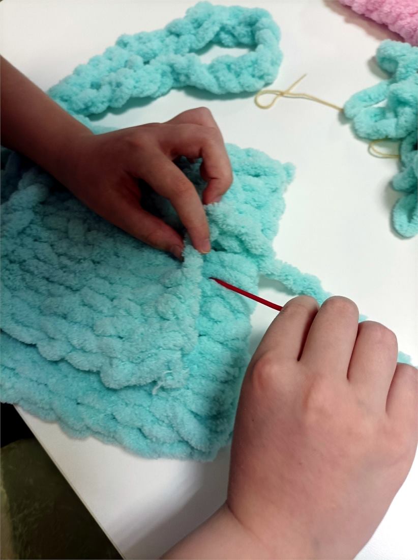 Руки вяжут мягкой пряжей Puffy без спиц и крючка